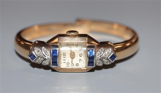 An Art Deco style 9ct gold, sapphire and diamond set bangle cocktail watch.